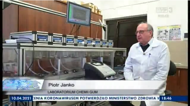 Przy stanowisku wzorcowym do badania alkomatów stoi mężczyzna w fartuchu. To kadr z materiału telewizyjnego, na dolnym pasku znajduje się podpis: Piotr Janko - Laboratorium Chemii GUM.